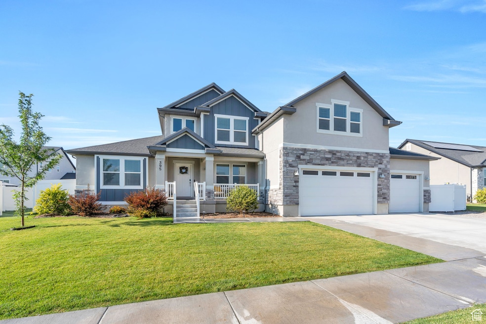 Craftsman-style house with driveway, a garage, stone siding, a front yard, and stucco siding