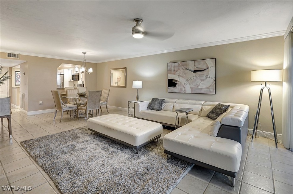 Tiled living room with crown molding and ceiling f