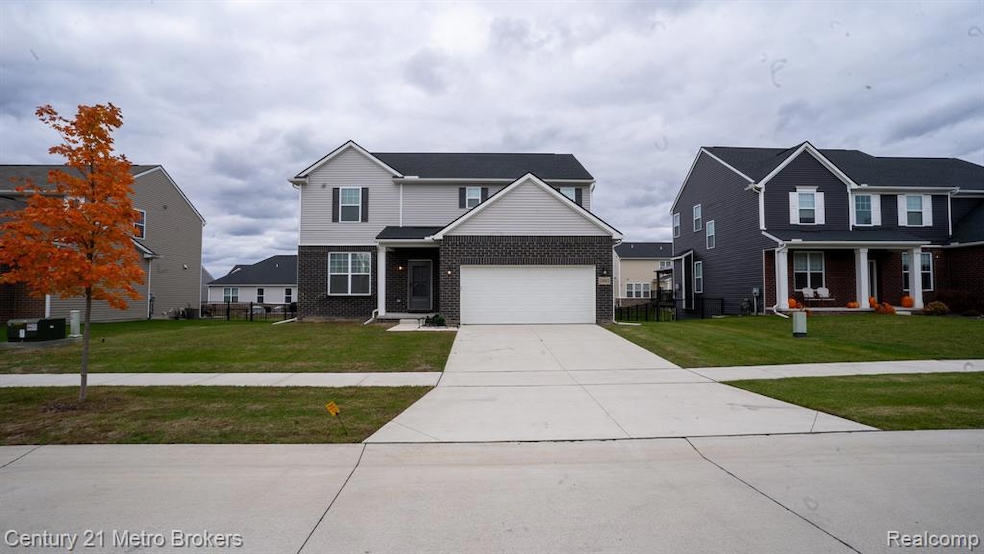 Traditional home with brick siding, driveway, and a garage