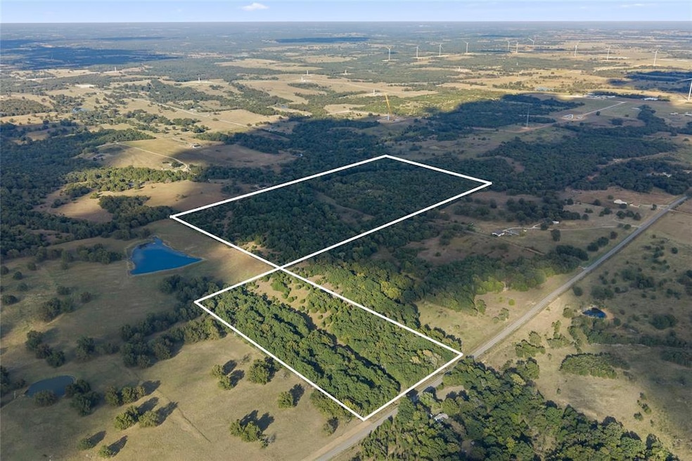 Aerial view of sparsely populated area with property boundaries highlighted and a large body of water