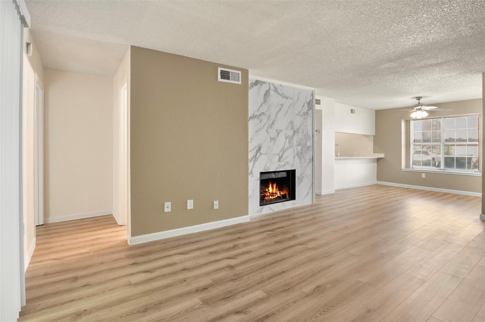 Unfurnished living room with ceiling fan, a firepl