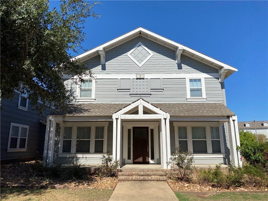 View of front of house with a shingled roof and a porch