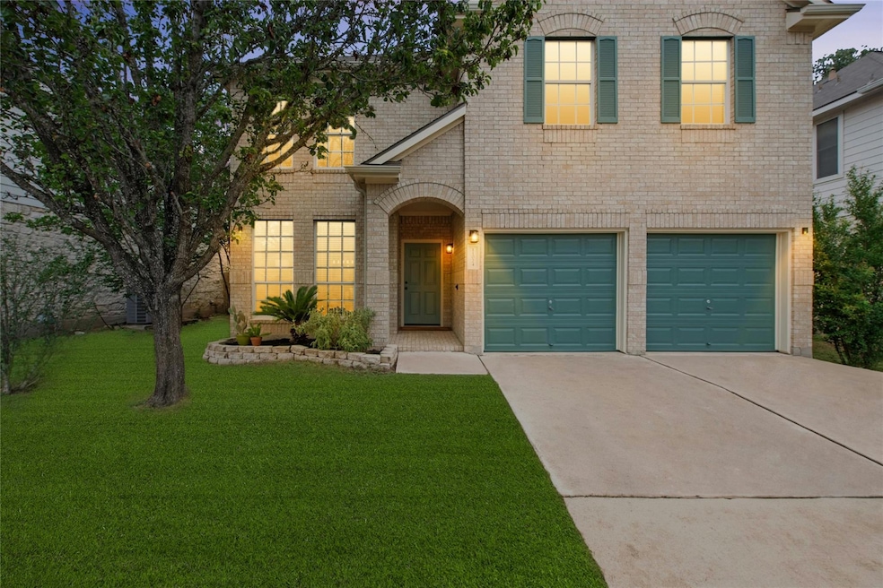 View of front facade with brick siding, driveway,