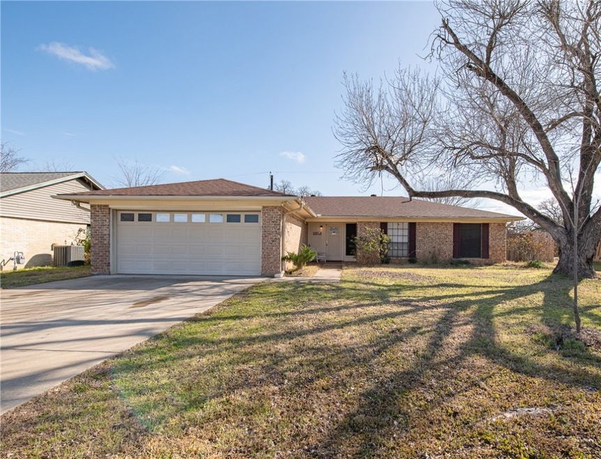 Ranch-style home with a garage, brick siding, conc