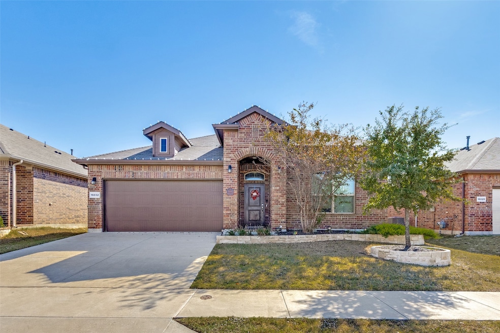 View of front facade with brick siding, concrete driveway, an attached garage, and a front yard