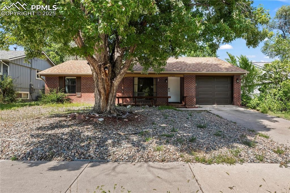 Single story home featuring a shingled roof, brick siding, concrete driveway, and an attached garage