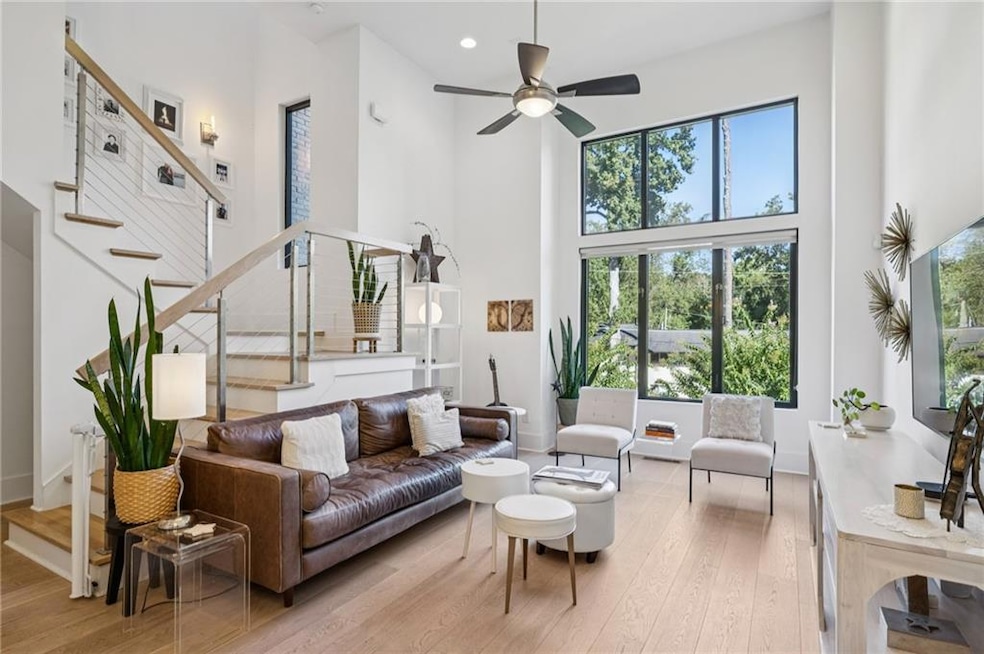 Living room with a towering ceiling and wall of windows