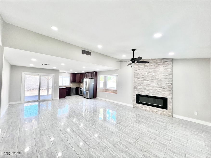 Unfurnished living room with a stone electric fireplace, recessed lighting, and ceiling fan