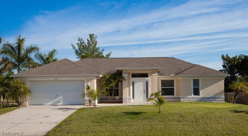 Front of home with cement driveway, stucco, metal