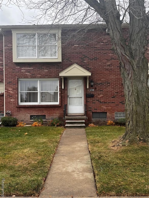 Entrance to property featuring brick siding and a yard