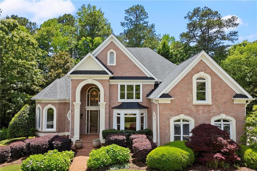 View of front of home with brick siding, a shingle