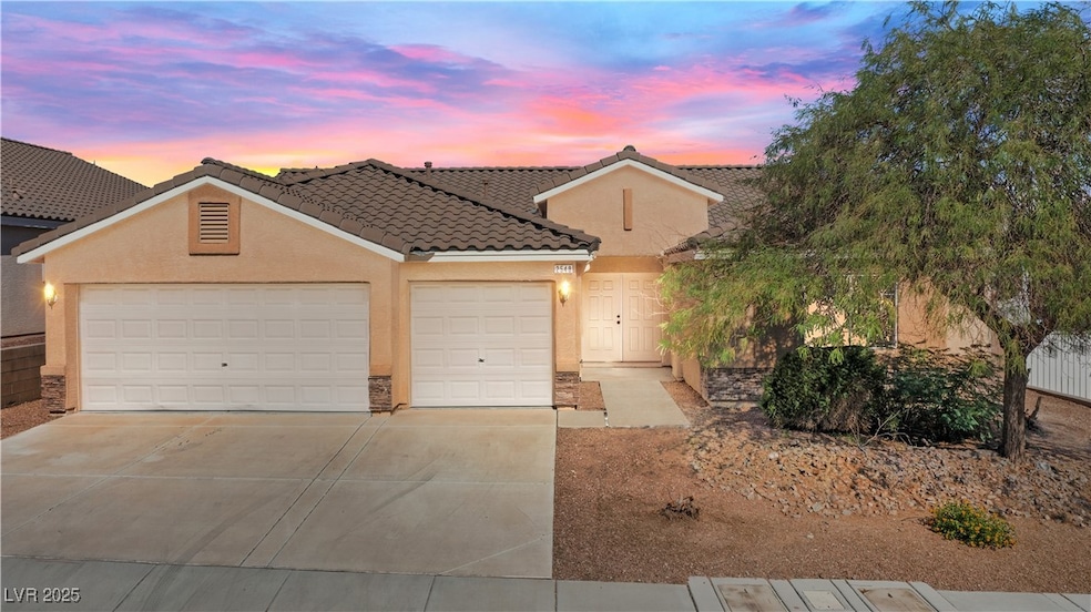View of front of property with driveway, stucco siding, a garage, and a tile roof