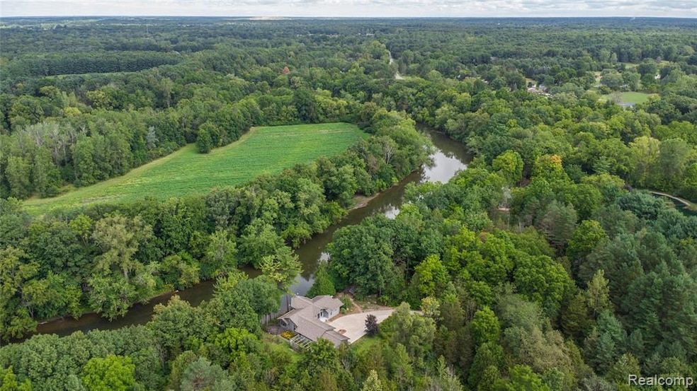 View of property location featuring a nearby body of water and a forest