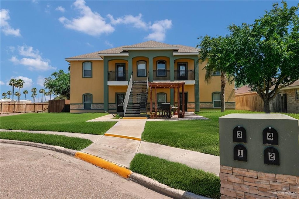 View of front facade featuring stairway and stucco siding