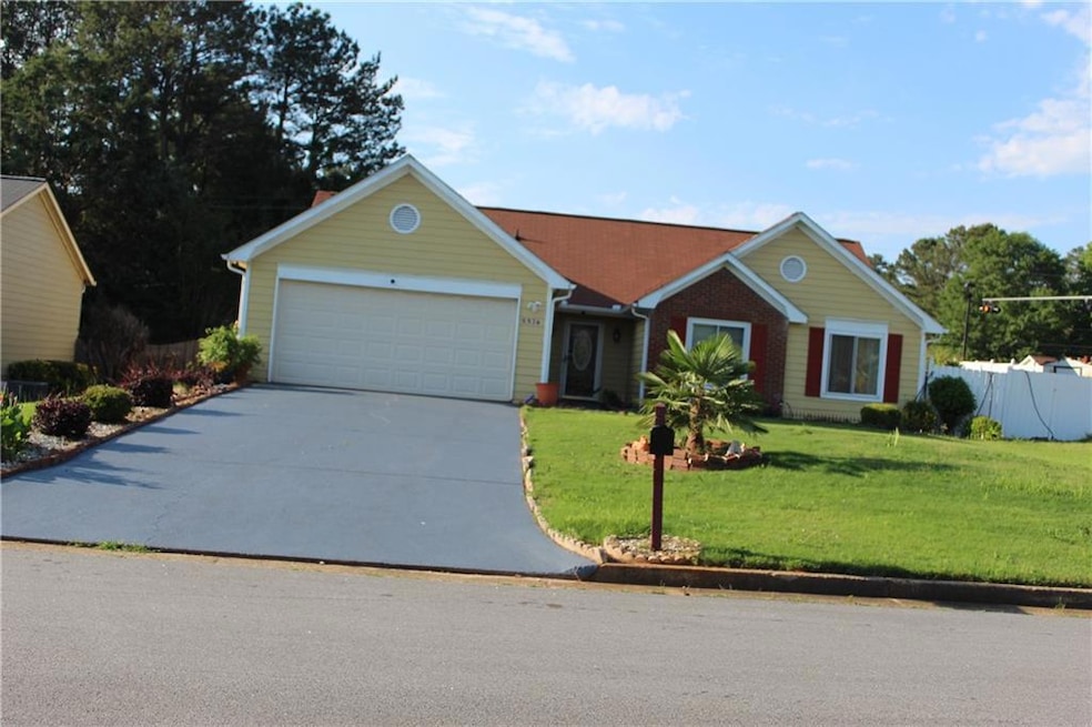 View of front of home with concrete driveway and an attached garage