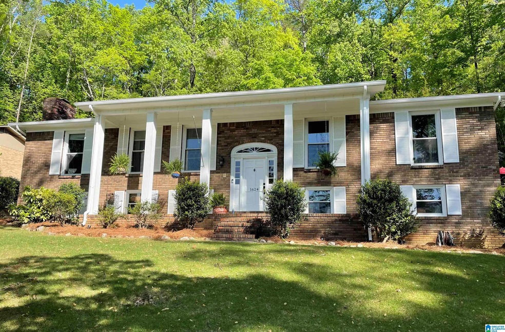 This stately brick home with its columns and matur