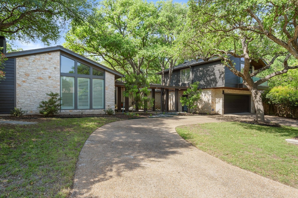 Mid-century home featuring curved driveway, stone