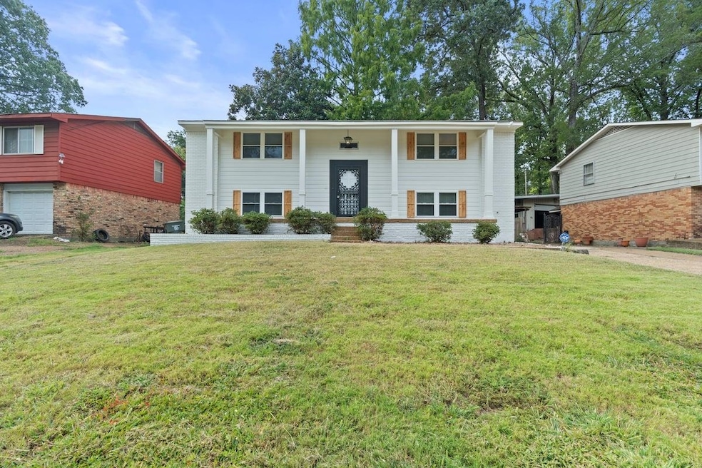 Split foyer home with a porch, a front lawn, and brick siding
