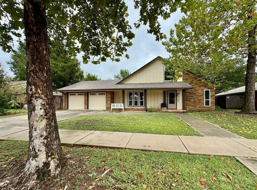 View of front of home with driveway, a porch, brick siding, an attached garage, and a shingled roof