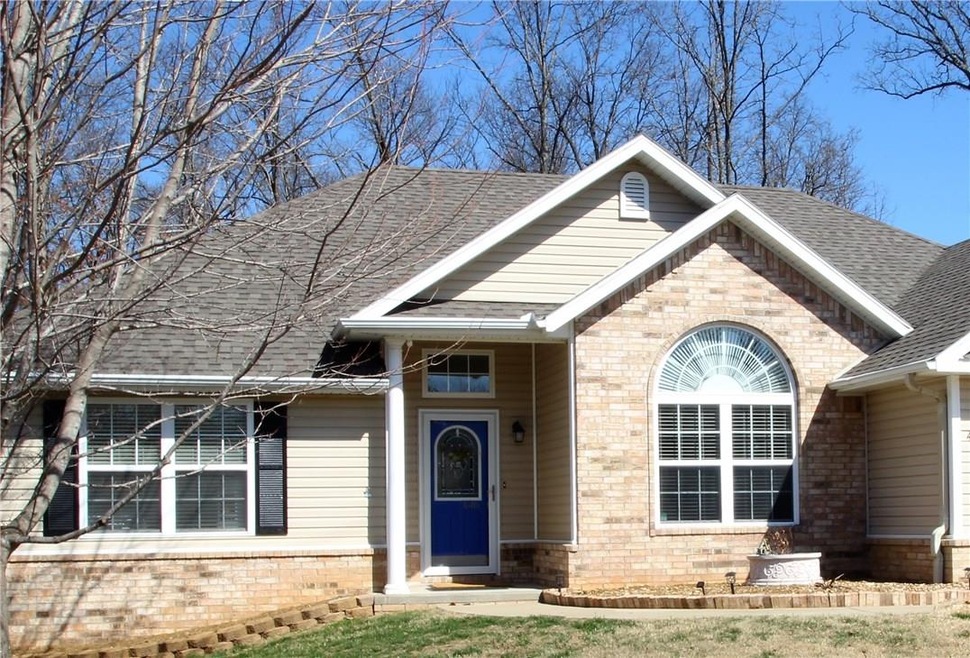 Pretty arched window surrounded by brick and transom window above front door lets the natural light shine in.  Sidewalk leads your guest straight to the front door!