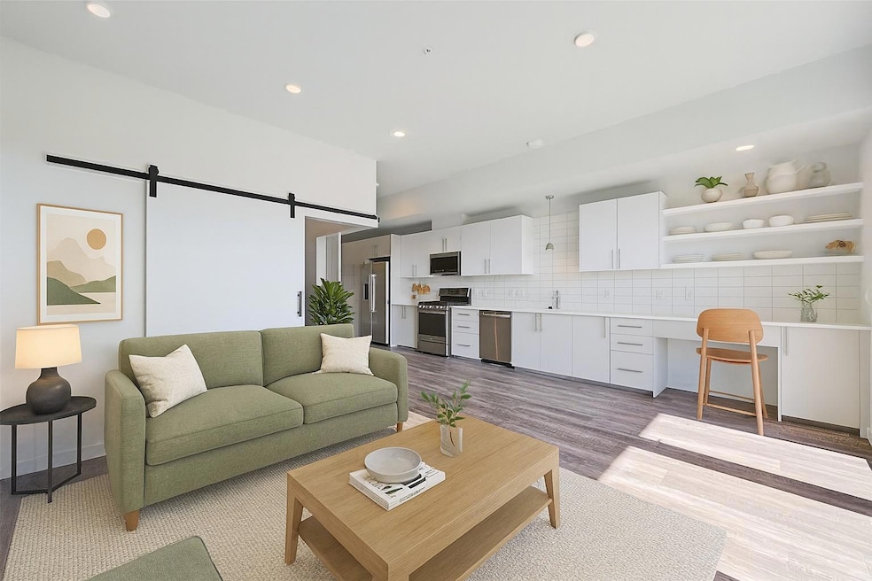 Living area featuring a barn door, light wood-sty