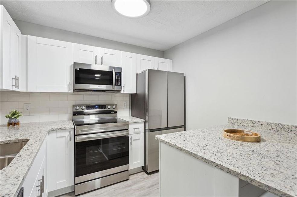 Kitchen with white cabinets, light wood-type floor