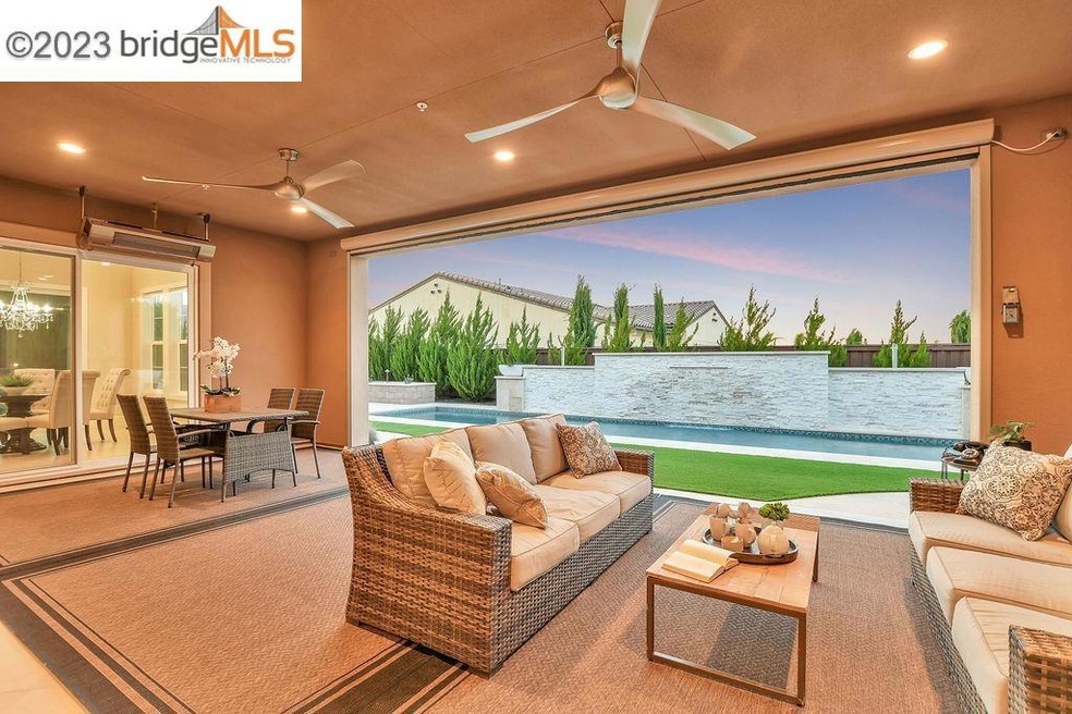 Covered patio with retractable screen overlooking a 50 foot pool