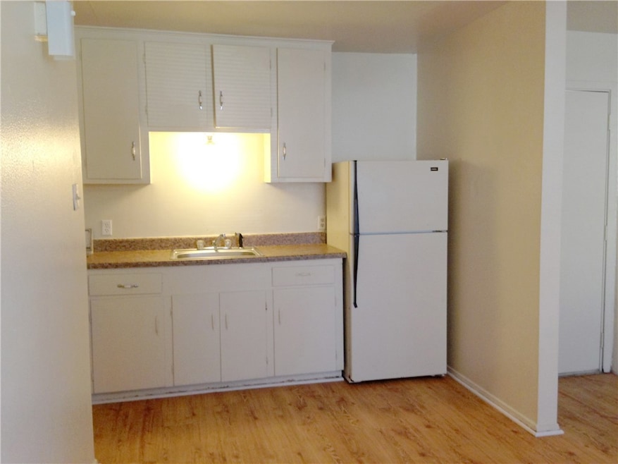 Kitchen with freestanding refrigerator, light wood
