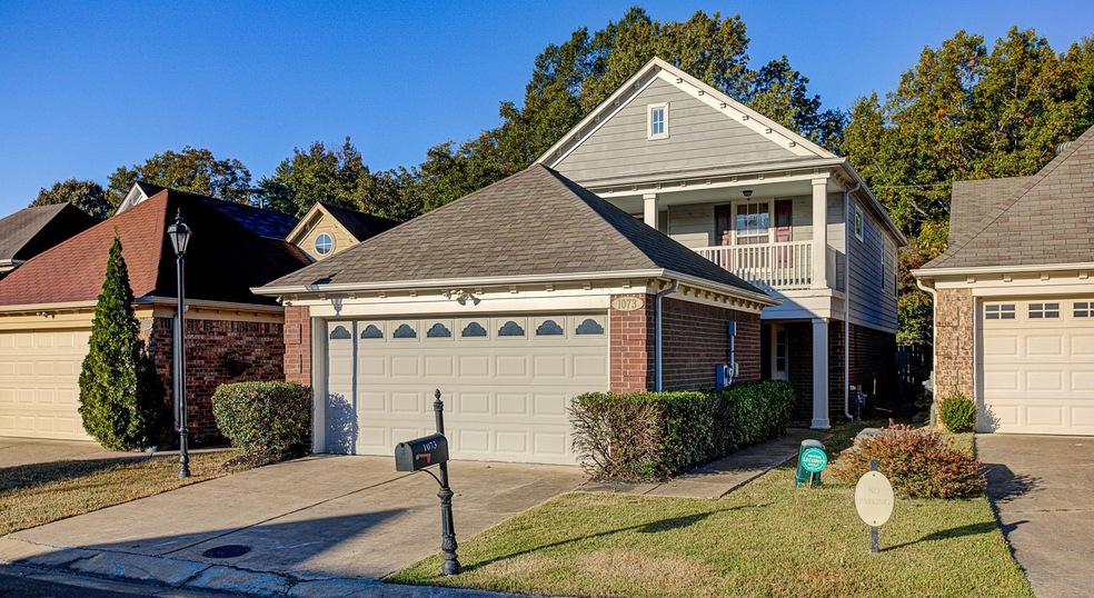 View of front property with a balcony, a garage, a
