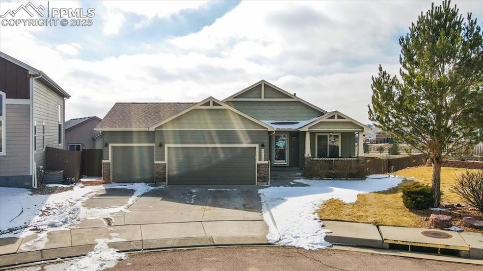 Craftsman-style house with an attached garage, concrete driveway, covered porch, and stone siding