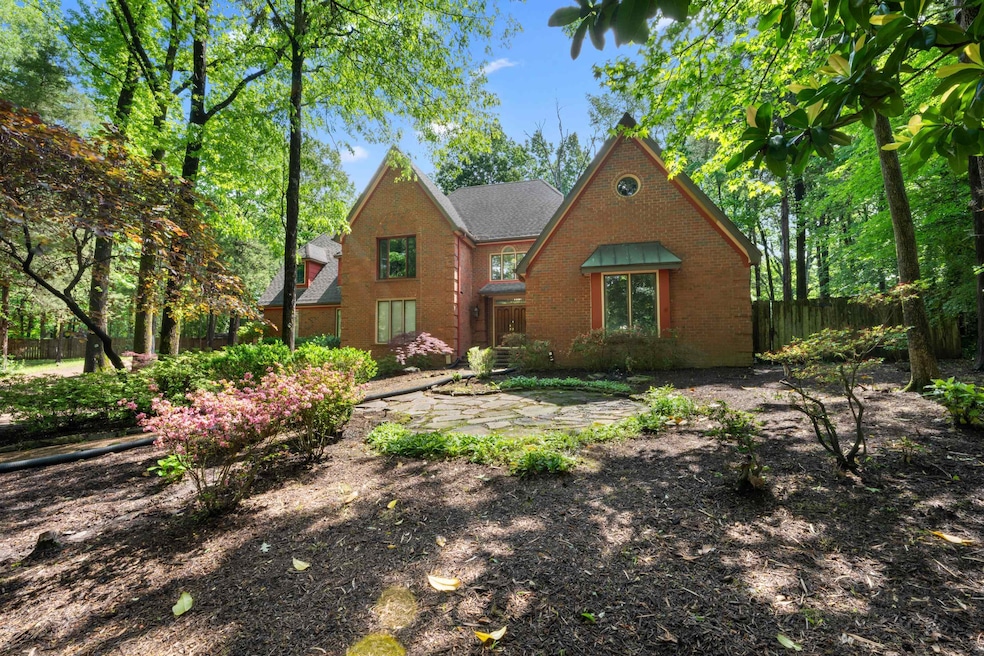 View of front facade with fence and brick siding