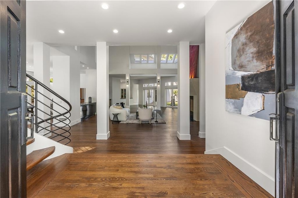 Foyer with stairs, recessed lighting, dark wood-style floors, and a towering ceiling