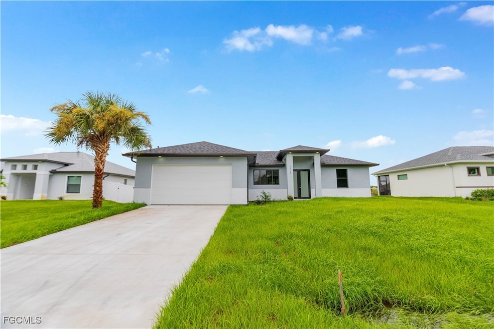 Prairie-style home with driveway, an attached garage, a front yard, and stucco siding