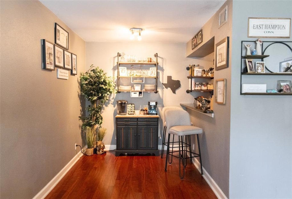 Bar featuring dark wood-style flooring and basebo