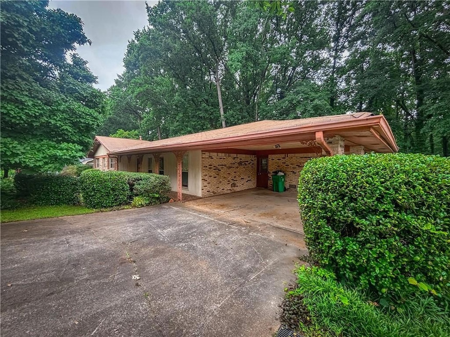 View of parking / parking lot with driveway and a carport
