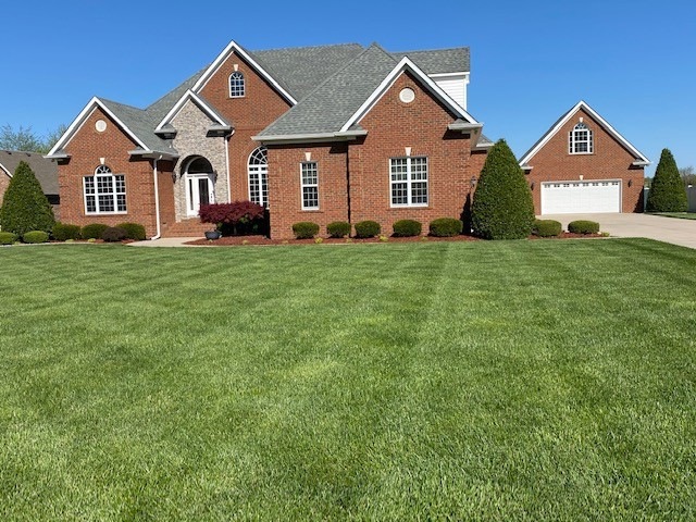 The curb appeal of this exquisite 3363 sq. ft. custom home is enhanced by the professional landscaping and lush green grass.