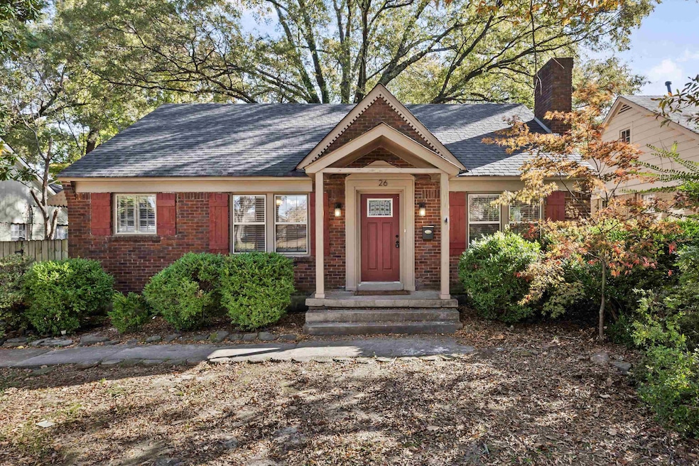 View of front facade featuring brick siding, a shingled roof, and a chimney