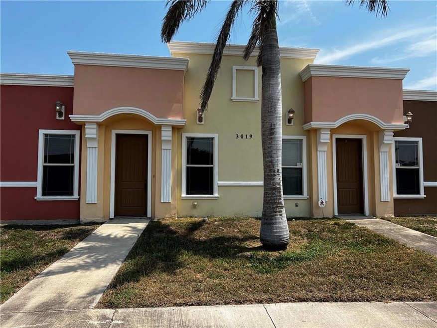 View of property with stucco siding and a front lawn