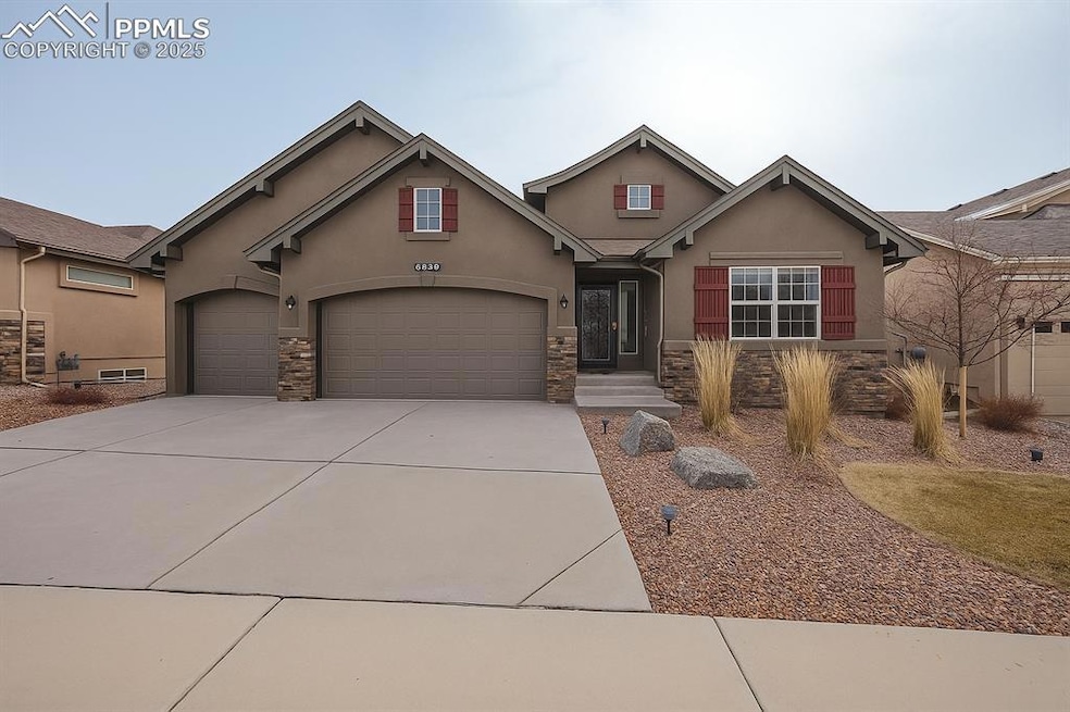 View of front of house with stone siding, stucco siding, concrete driveway, and an attached garage