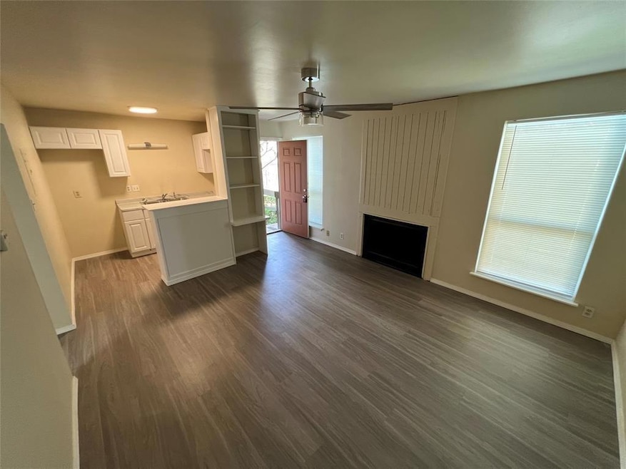 Unfurnished living room with a ceiling fan, dark 