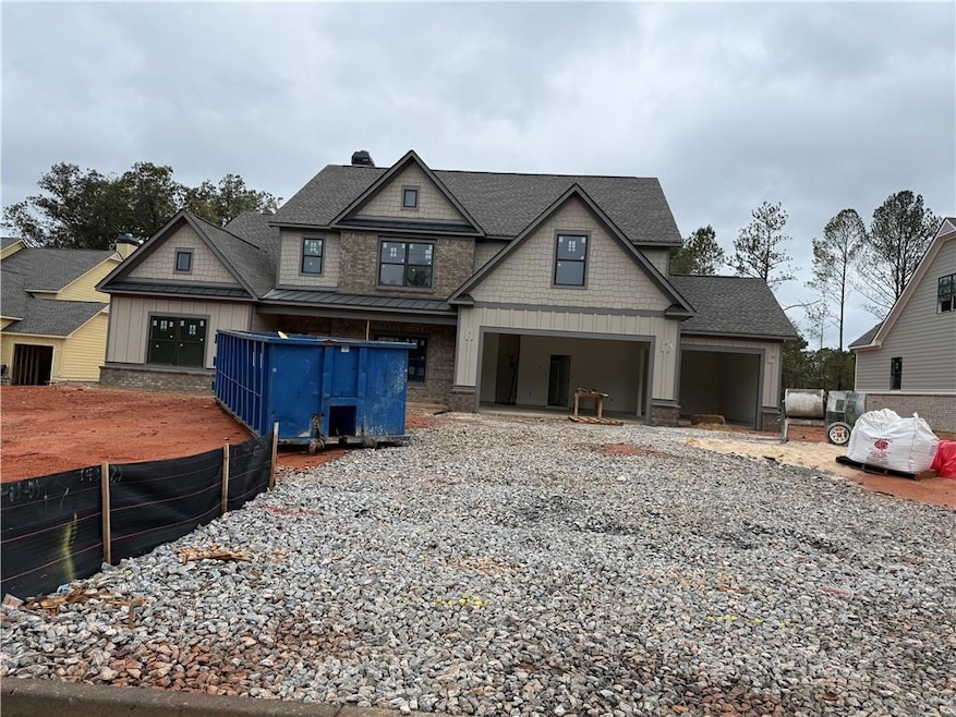 Craftsman house with board and batten siding, a chimney, roof with shingles, a garage, and gravel driveway