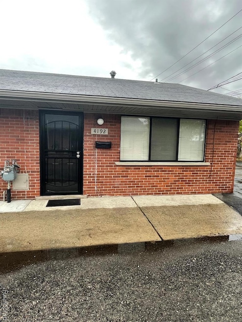 Entrance to property featuring brick siding and roof with shingles