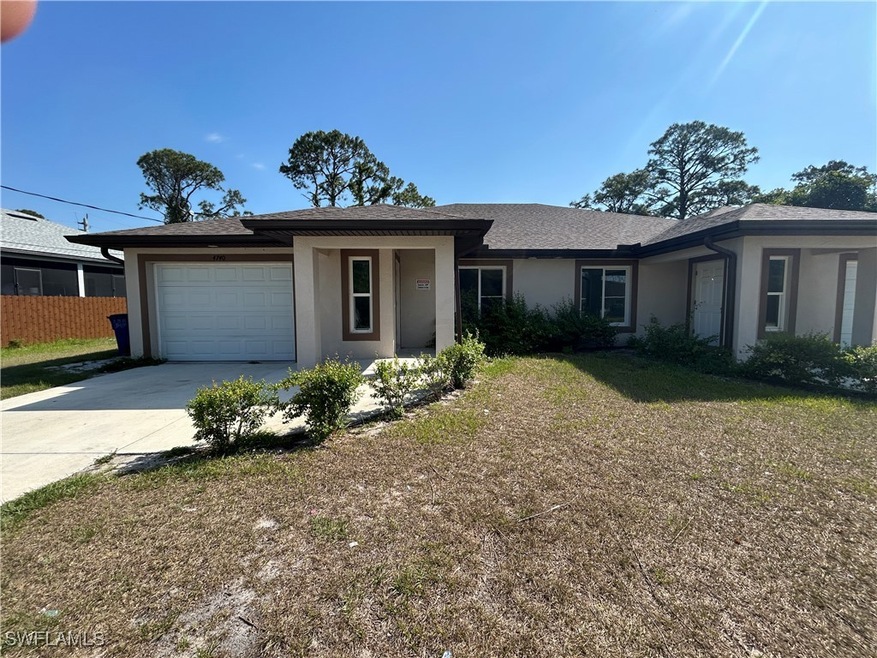 View of front of property with a garage, stucco si