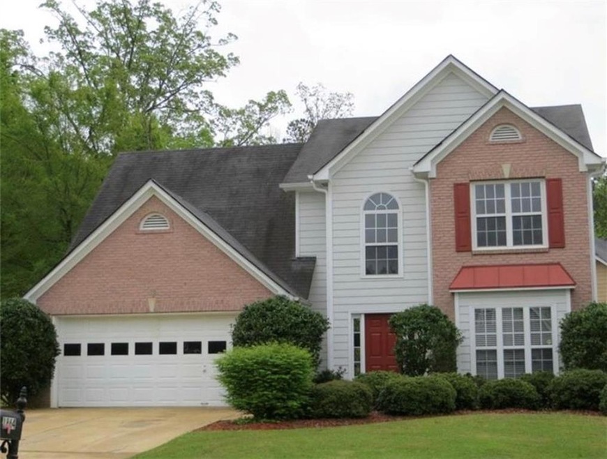 View of property featuring a garage and a front la