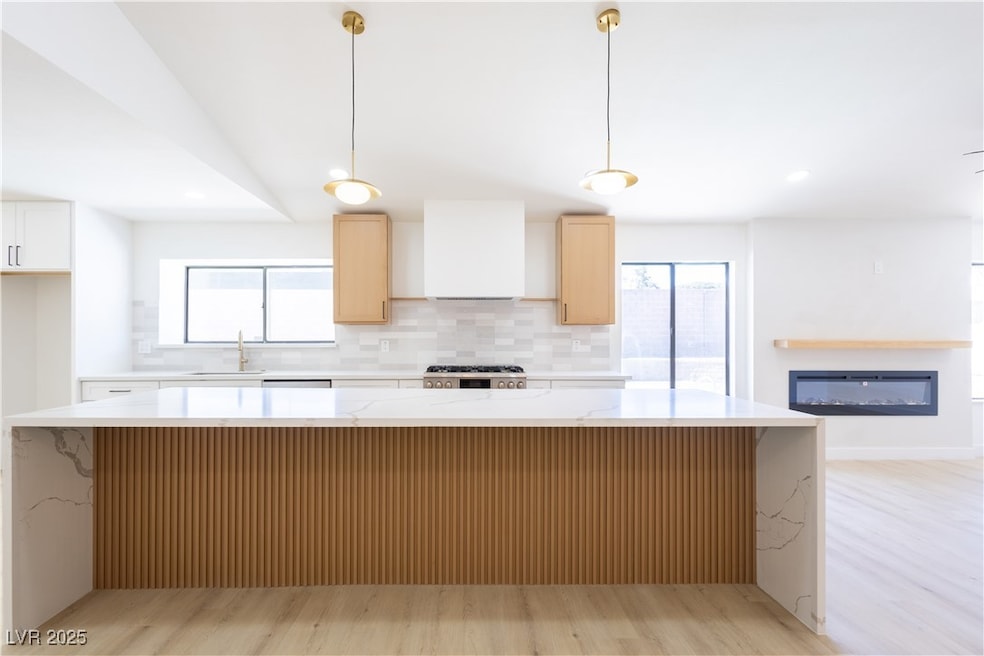 Kitchen with range, custom range hood, a sink, and