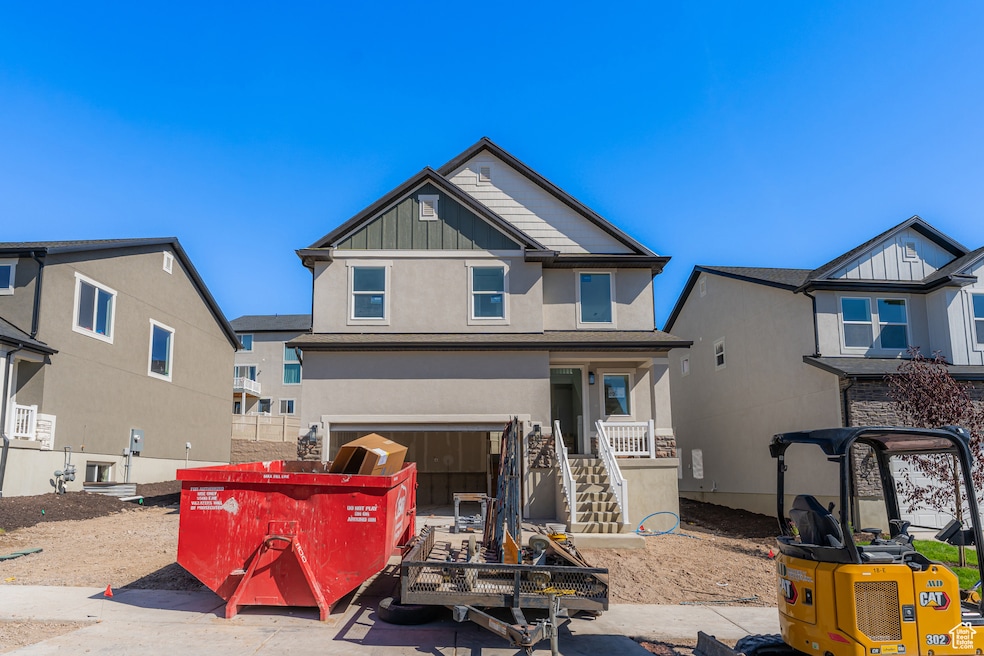 View of front of house featuring stucco siding, stairs, an attached garage, and board and batten siding