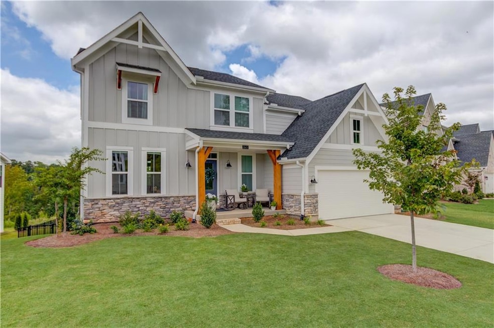 View of front of property featuring board and batten siding, a porch, stone siding, and roof with shingles