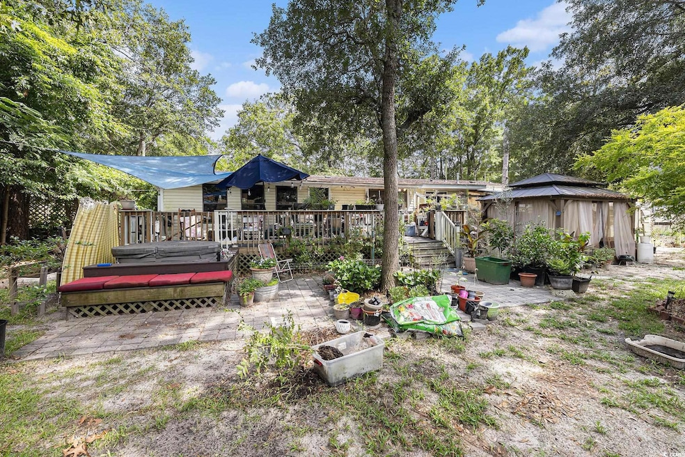 Back of house with a gazebo, a wooden deck, and a patio area
