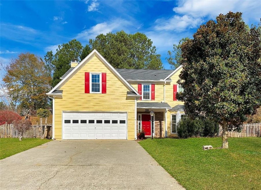 Front of property featuring a front yard and a gar
