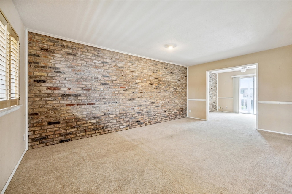 LIVING ROOM WITH LARGE BRICK ACCENT WALL